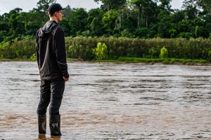 Visitor standing at the riverbank observing the Amazon landscape
